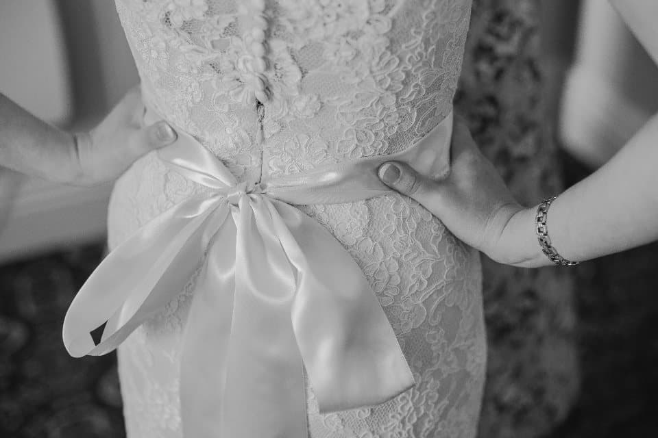 The back of a lace wedding dress, tied with a satin bow