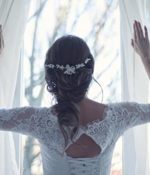 A bride opening the curtains on her wedding morning